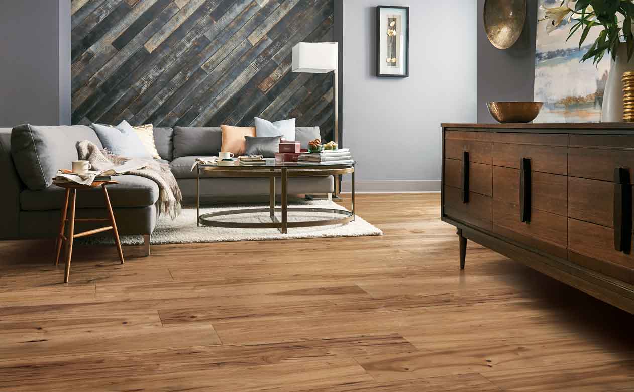 warm toned hardwood flooring in cozy modern living room with gray wood walls